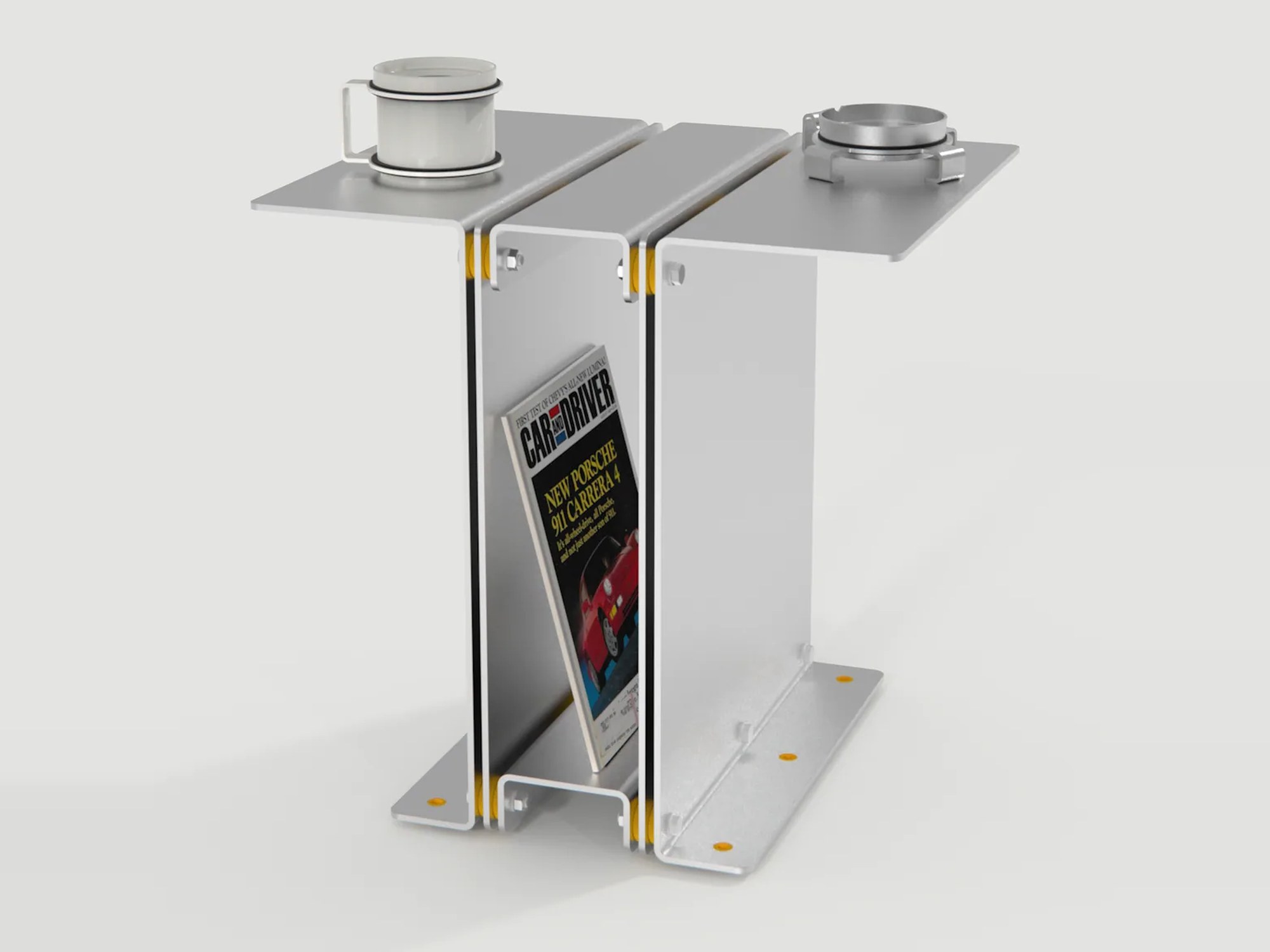 3082 Book Table in raw aluminum, holding a magazine, a mug and an ashtray